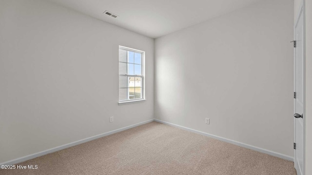 unfurnished room with carpet, visible vents, and baseboards