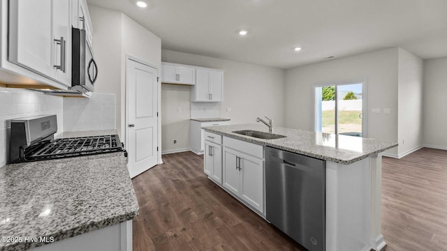 kitchen with dark wood-style flooring, white cabinetry, stainless steel appliances, and a sink