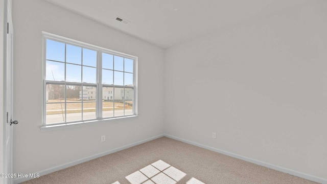 carpeted empty room with baseboards and visible vents