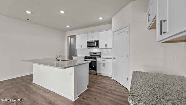 kitchen with a sink, decorative backsplash, dark wood finished floors, and stainless steel appliances