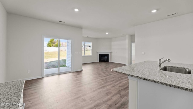 kitchen featuring recessed lighting, wood finished floors, visible vents, and a sink