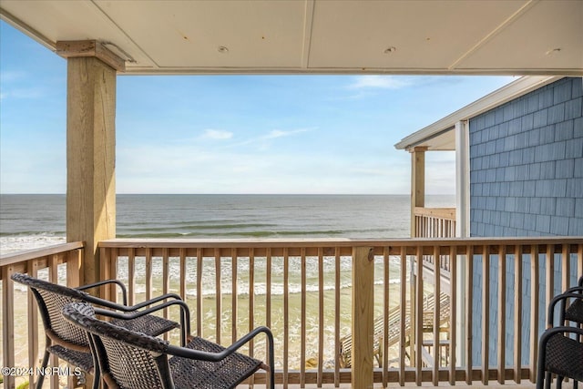 balcony featuring a water view and a view of the beach
