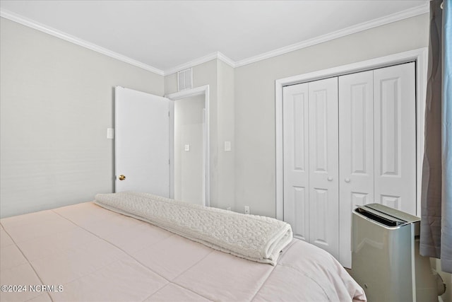 bedroom featuring ornamental molding, a closet, and visible vents