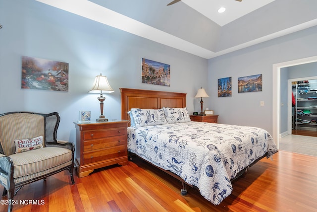 bedroom featuring a spacious closet, a closet, light hardwood / wood-style flooring, and ceiling fan