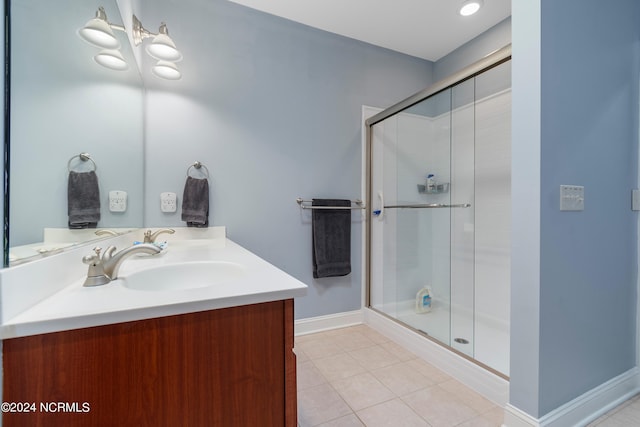 bathroom featuring tile patterned floors, an enclosed shower, and vanity