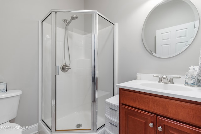 bathroom with toilet, a shower with door, and vanity