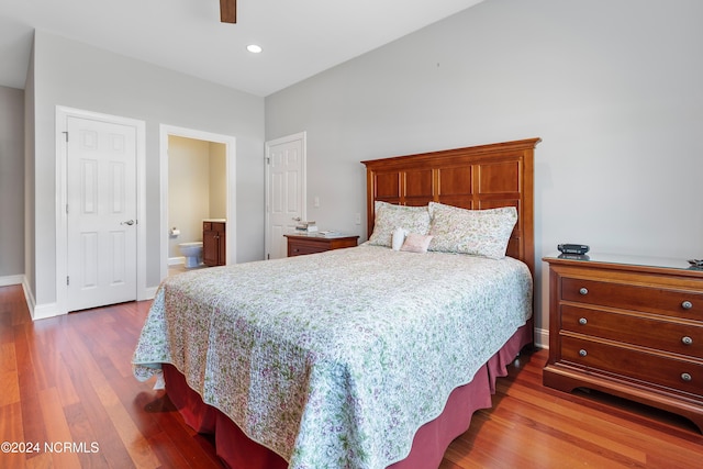 bedroom with ensuite bathroom, ceiling fan, and hardwood / wood-style floors