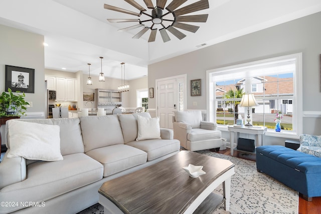 living room with ceiling fan, sink, and light hardwood / wood-style flooring