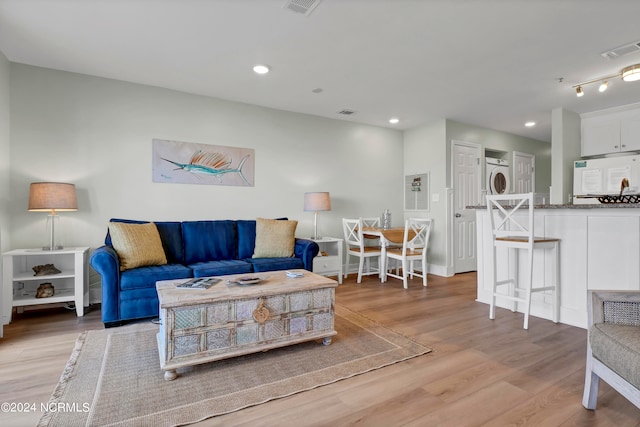 living room featuring light hardwood / wood-style flooring and stacked washer and clothes dryer