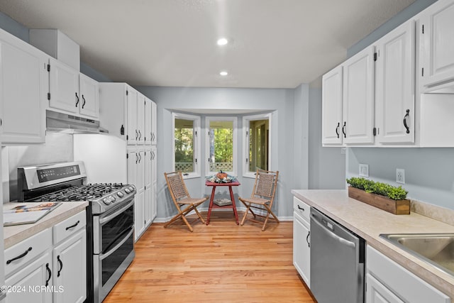 kitchen with white cabinets, light wood-type flooring, sink, and appliances with stainless steel finishes