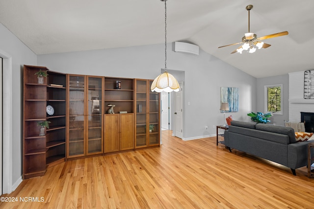 living room featuring a fireplace, light wood-type flooring, vaulted ceiling, and ceiling fan