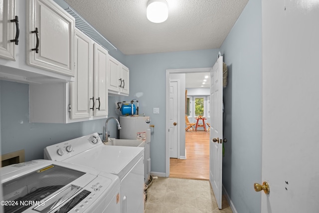 laundry room featuring cabinets, separate washer and dryer, a textured ceiling, and water heater