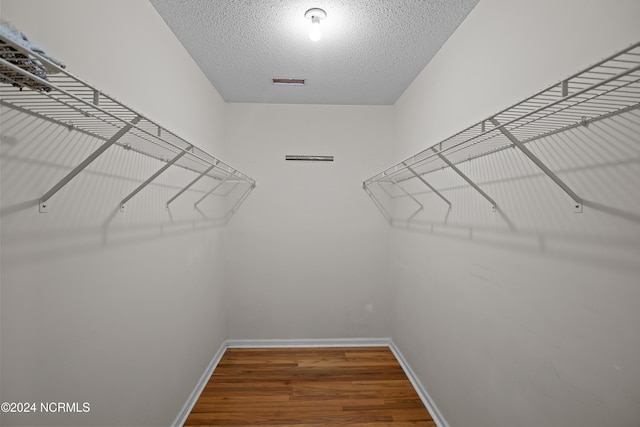 spacious closet with dark hardwood / wood-style floors