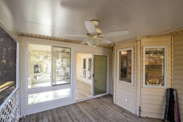 unfurnished sunroom featuring ceiling fan