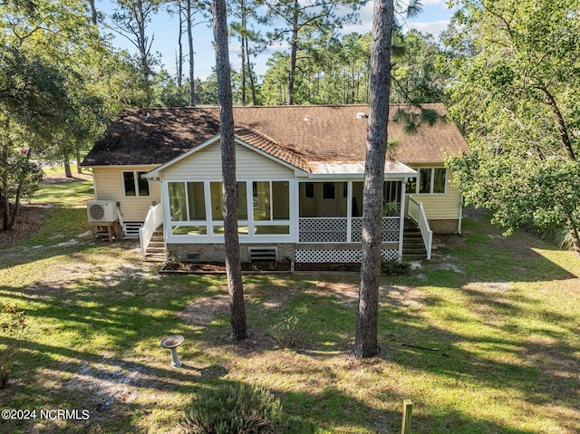 back of property featuring a lawn, a sunroom, and ac unit