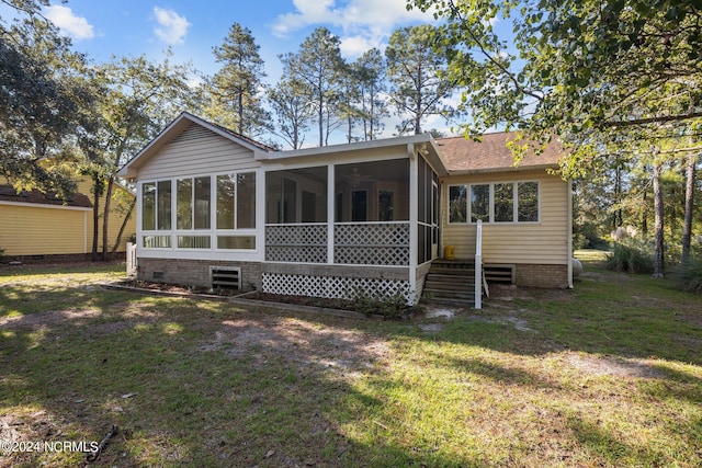 back of house featuring a yard and a sunroom