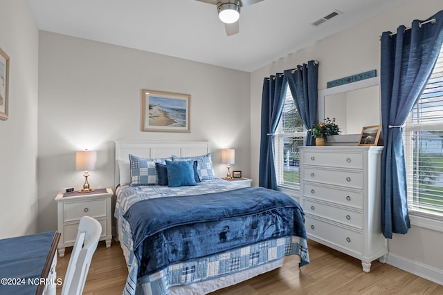 bedroom with multiple windows, ceiling fan, and light hardwood / wood-style flooring