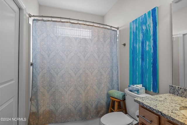 bathroom featuring a shower with curtain, vanity, and toilet