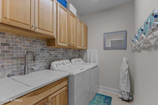 washroom with washing machine and clothes dryer, cabinets, light tile patterned floors, and sink