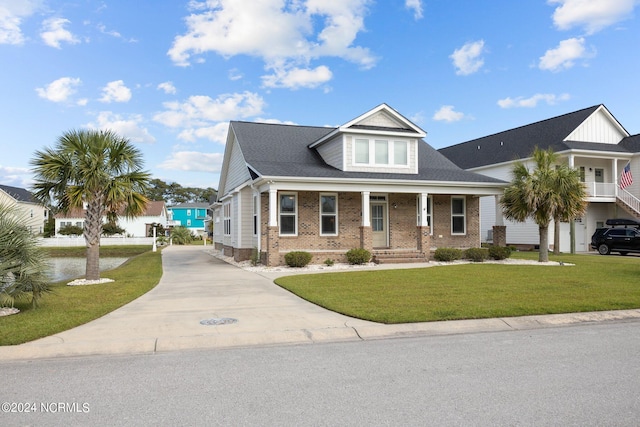 view of front of house with a front lawn, covered porch, and a garage