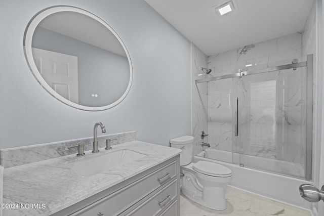 full bathroom featuring vanity, combined bath / shower with glass door, and toilet