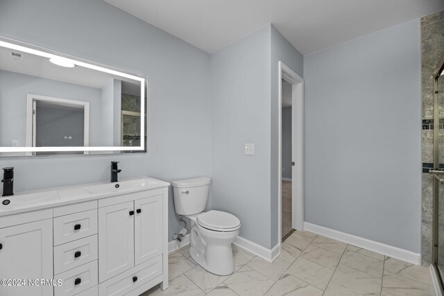 bathroom featuring vanity, toilet, and an enclosed shower