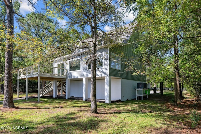 view of side of property with a wooden deck and a yard