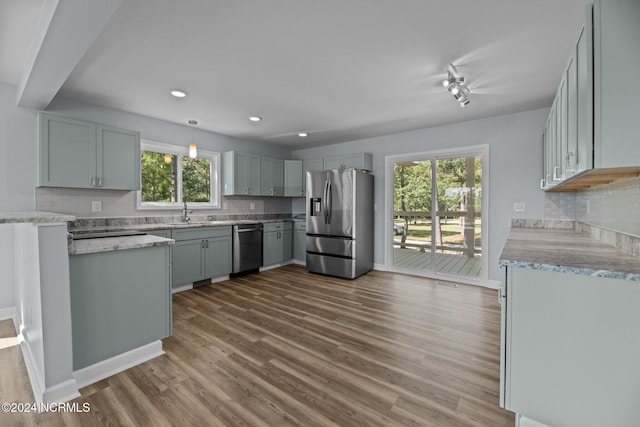 kitchen featuring gray cabinets, a healthy amount of sunlight, dark hardwood / wood-style floors, and stainless steel appliances