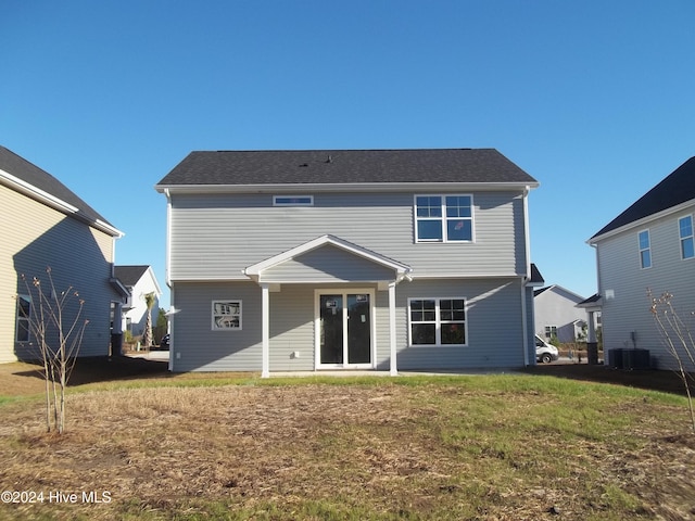 back of property featuring a yard and central AC