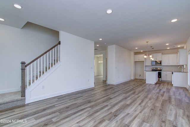 unfurnished living room with light wood-type flooring and sink