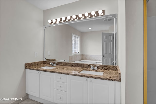 bathroom with vanity and a washtub