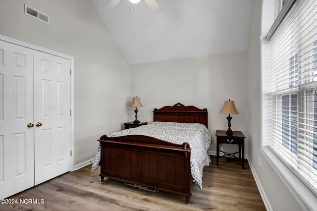 bedroom featuring vaulted ceiling, hardwood / wood-style flooring, multiple windows, and ceiling fan