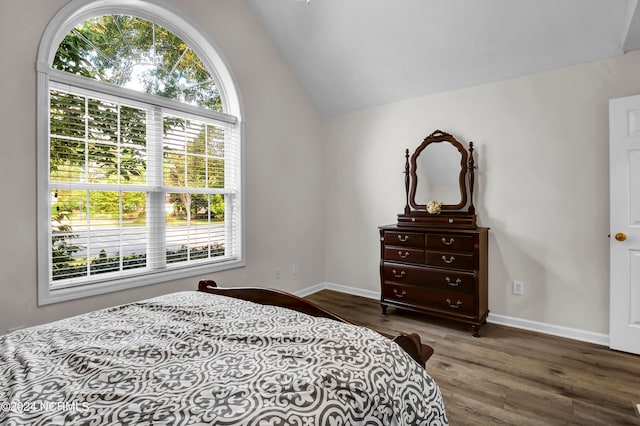 bedroom with lofted ceiling and dark hardwood / wood-style floors