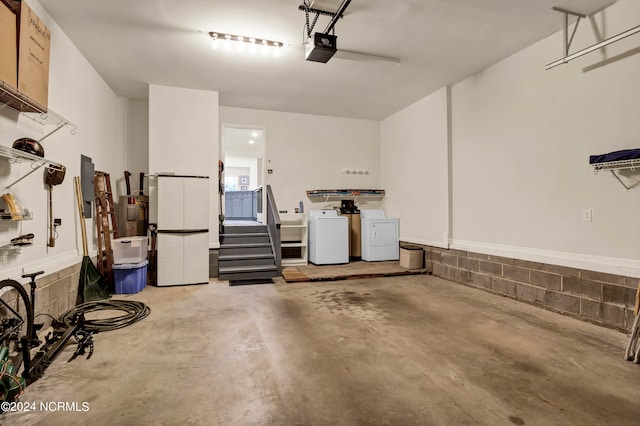 garage with a garage door opener and washing machine and dryer