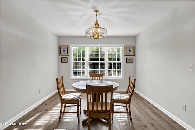 dining area with an inviting chandelier and dark hardwood / wood-style flooring