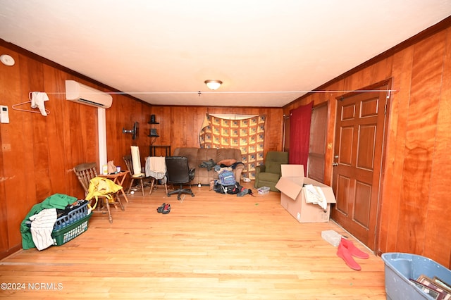 office featuring light wood-type flooring, wood walls, crown molding, and a wall mounted air conditioner