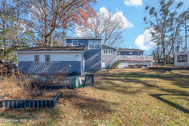 back of property featuring a wooden deck and a yard