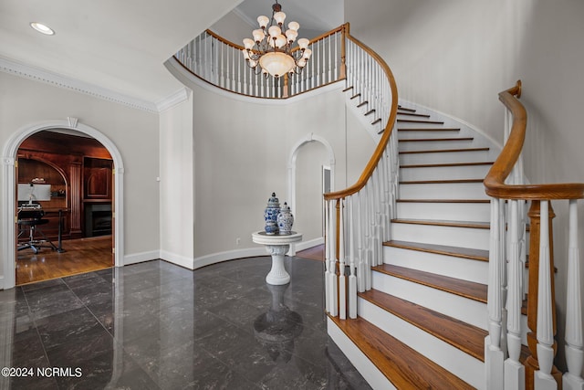 entrance foyer with an inviting chandelier and crown molding