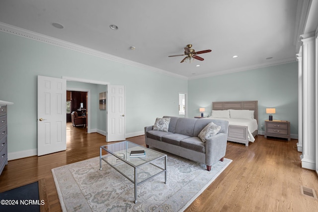 bedroom featuring light hardwood / wood-style flooring, ornate columns, ceiling fan, and crown molding