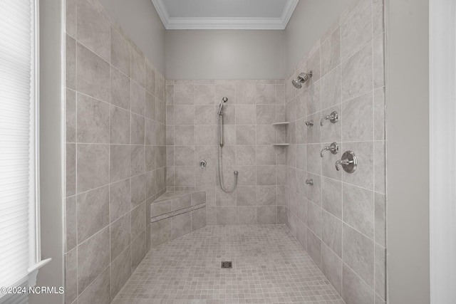 bathroom featuring crown molding and tiled shower