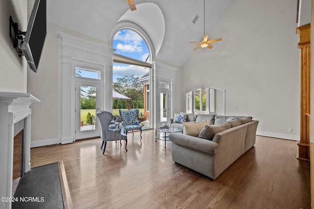 living room with high vaulted ceiling, wood-type flooring, ceiling fan, and plenty of natural light