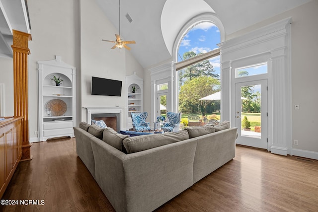 living room with high vaulted ceiling, hardwood / wood-style flooring, and plenty of natural light