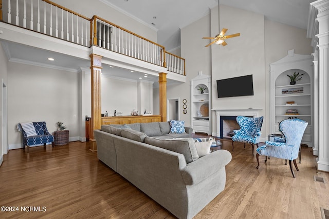 living room featuring high vaulted ceiling, ceiling fan, hardwood / wood-style flooring, and ornate columns