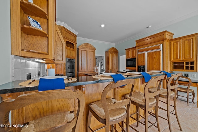 kitchen featuring built in appliances, a kitchen bar, decorative backsplash, light tile patterned floors, and crown molding