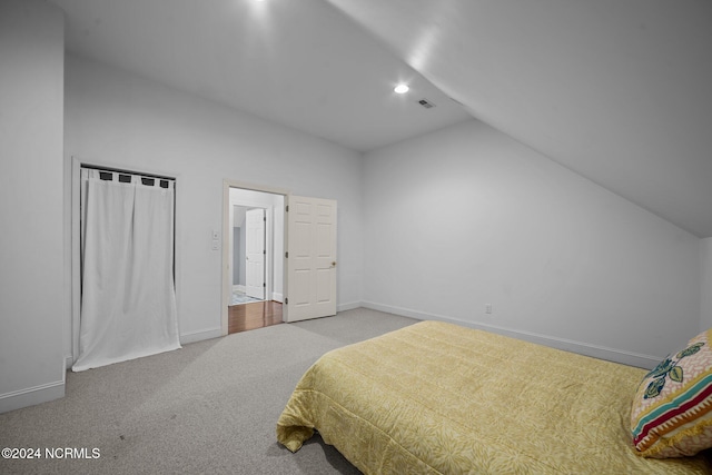 carpeted bedroom with lofted ceiling