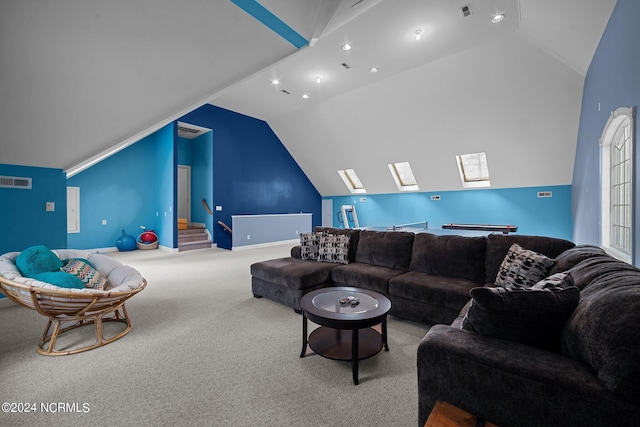 living room with vaulted ceiling with skylight and light colored carpet