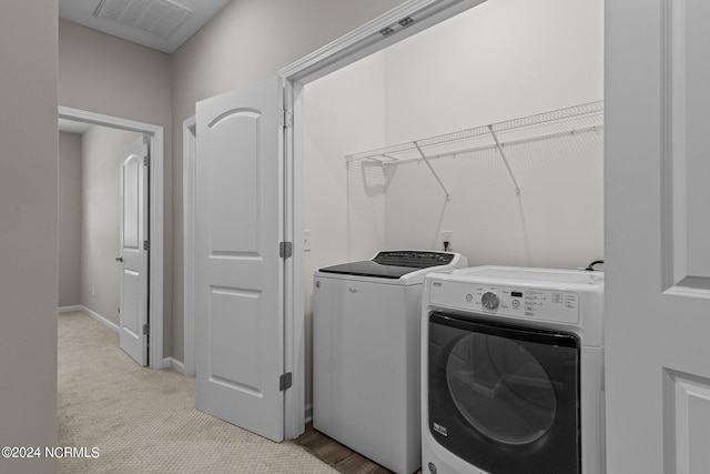 washroom with separate washer and dryer and light colored carpet