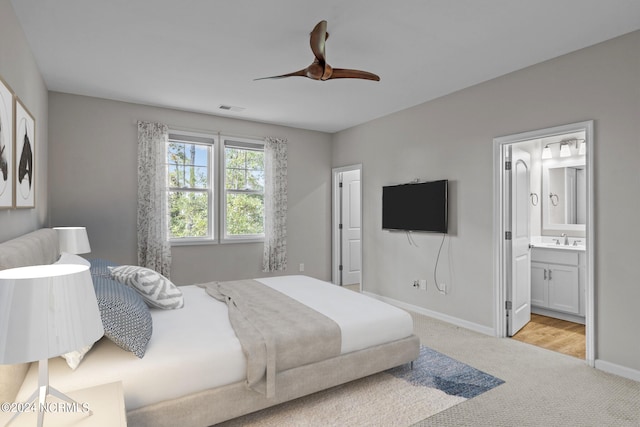 carpeted bedroom featuring ceiling fan, sink, and ensuite bath