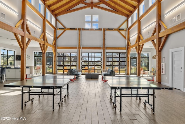 playroom with beam ceiling, high vaulted ceiling, and a healthy amount of sunlight