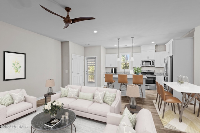 living room with ceiling fan, sink, and light hardwood / wood-style flooring